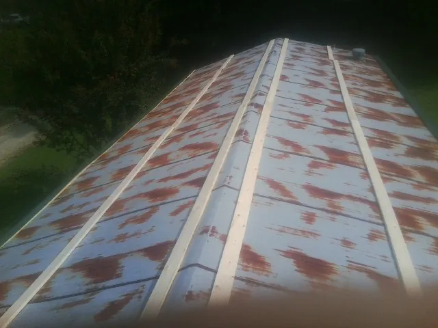 Rusted metal roof panels with new wood purlins before replacement — Storm Damage Roof Repair in Plainfield by Roofing Brothers