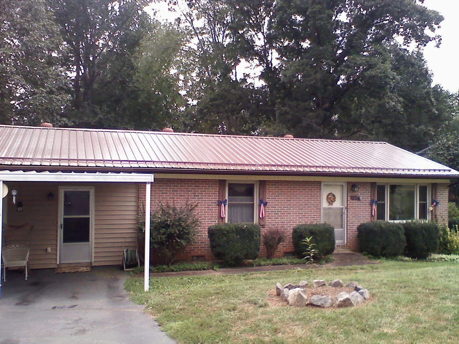 Bronze metal roof and carport on a brick ranch home — Roof Repair work by our crew in Plainfield
