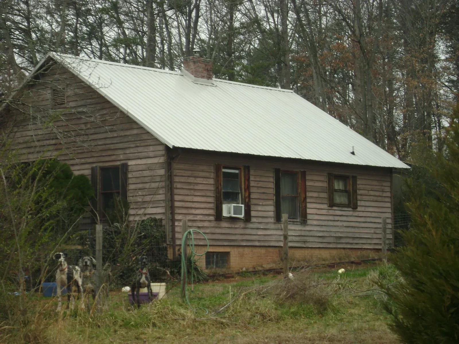 White metal roof on an old wood sided farmhouse, from a Metal Roof Installation job in Plainfield